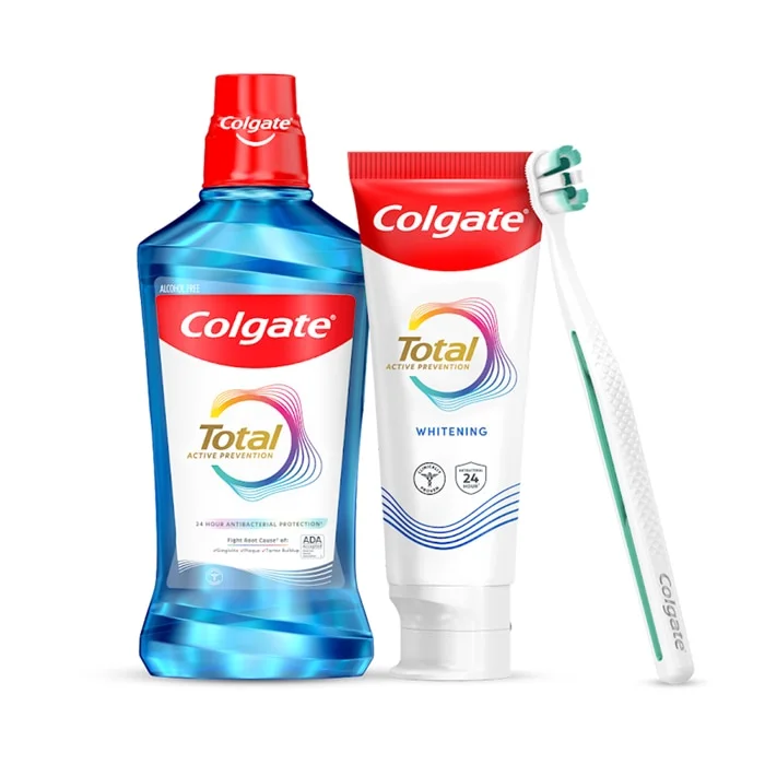 Colgate Total mouthwash, whitening toothpaste and a manual toothbrush arranged together on a white background.