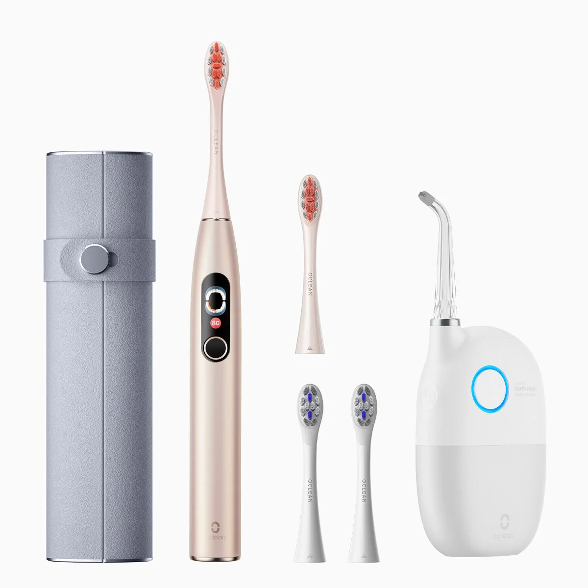 Oclean electric toothbrush, travel case and three spare heads beside a white cordless water flosser.