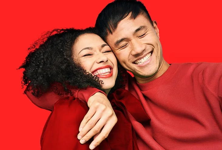 Two friends smiling together in a Colgate oral-care campaign photograph.