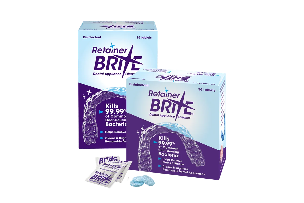 Two Retainer Brite cleaner boxes, marked 96 and 36 tablets, with individual sachets and blue cleaning tablets.